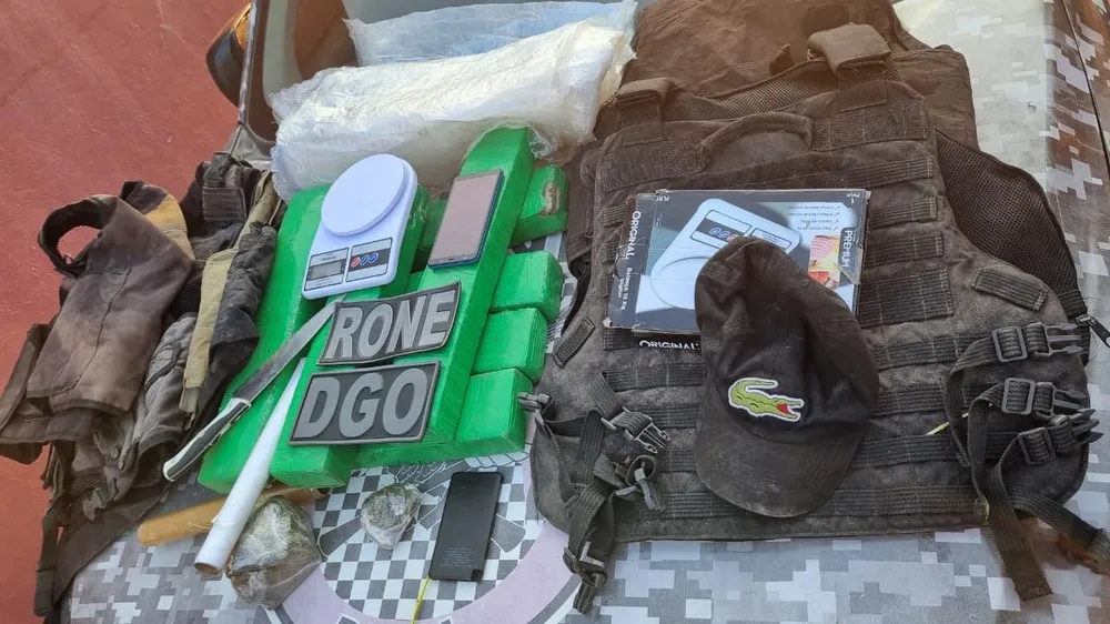 Tabletes de droga, balança de precisão e coletes à prova de bala.